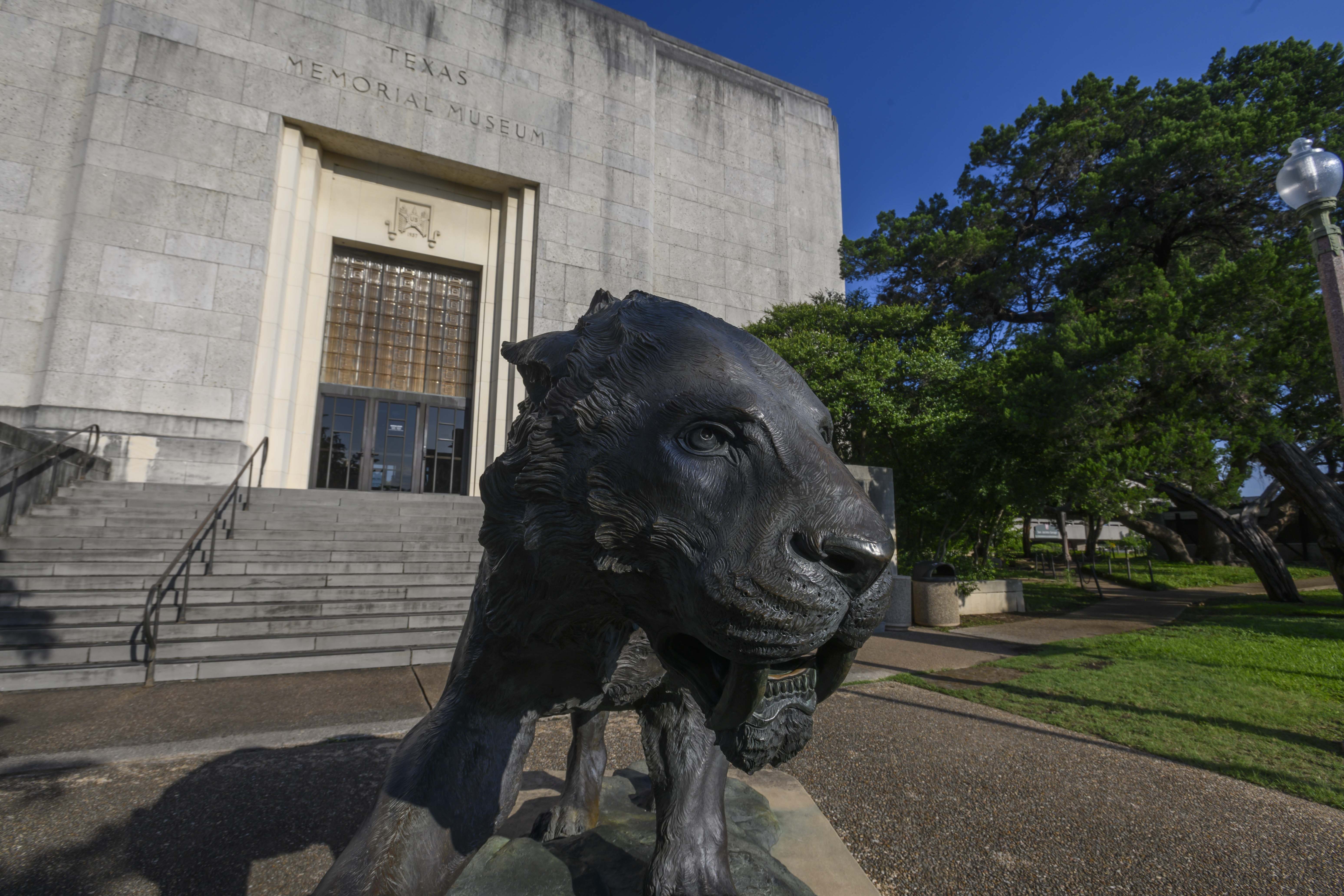 Exterior of the museum with saber tooth cat sculpture in foreground