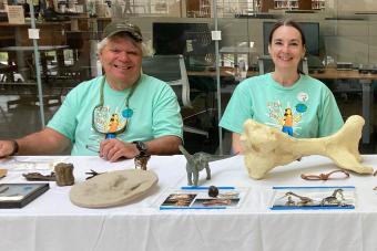 man and woman sitting at table displaying fossils