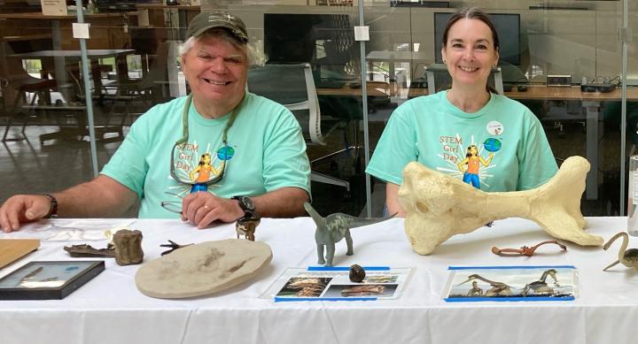 man and woman sitting at table displaying fossils