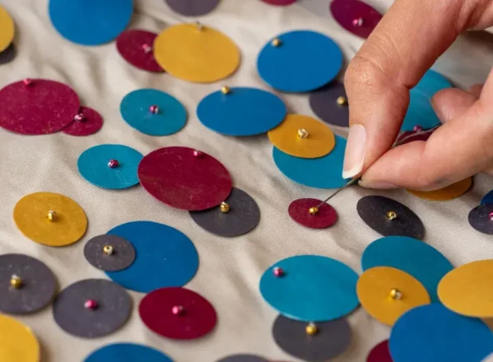 Close up of hand sewing sequins