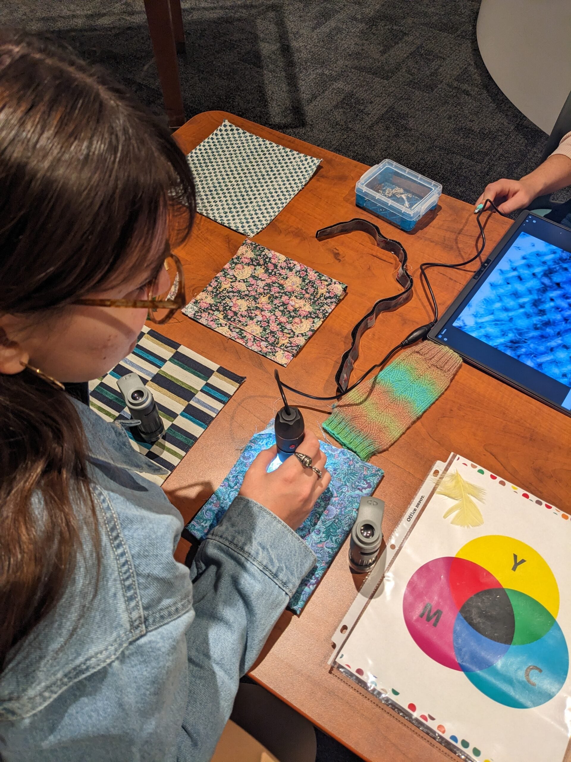 Visitor exploring fabric under microscope